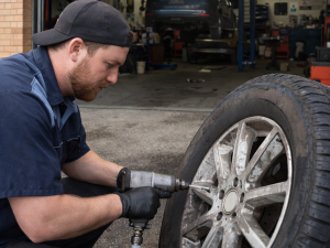 Mechanic repairing a car tire in an auto shop in Calgary